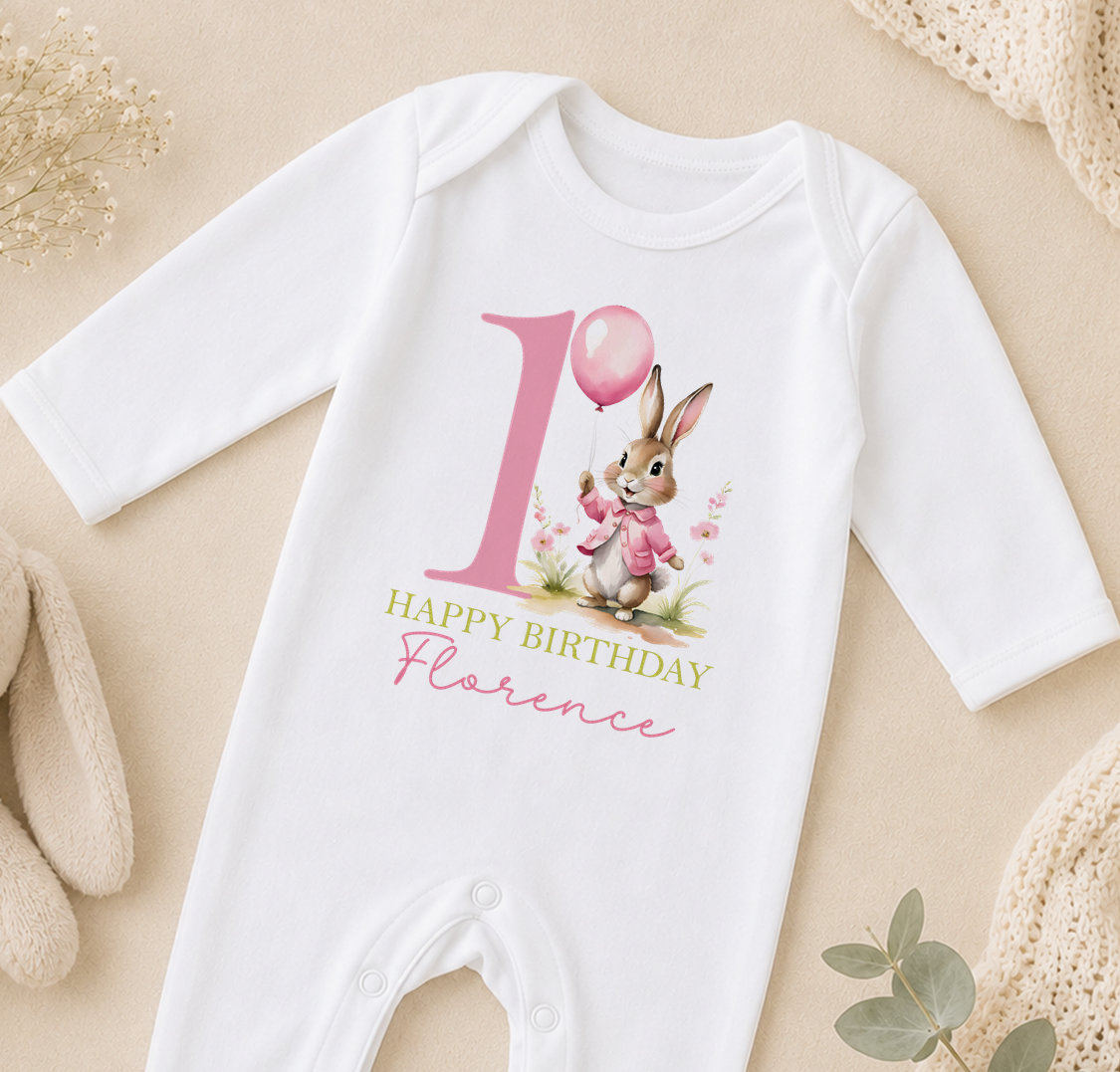A white onesie with a pink bunny and a pink balloon on it, along with the text "Happy Birthday Florence".