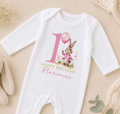 A white onesie with a pink bunny and a pink balloon on it, along with the text "Happy Birthday Florence".