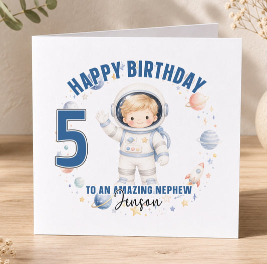 A personalised birthday card featuring a young boy in a spacesuit illustration, with the number 5 and the message 'Happy Birthday to an amazing nephew Jenessan'.
