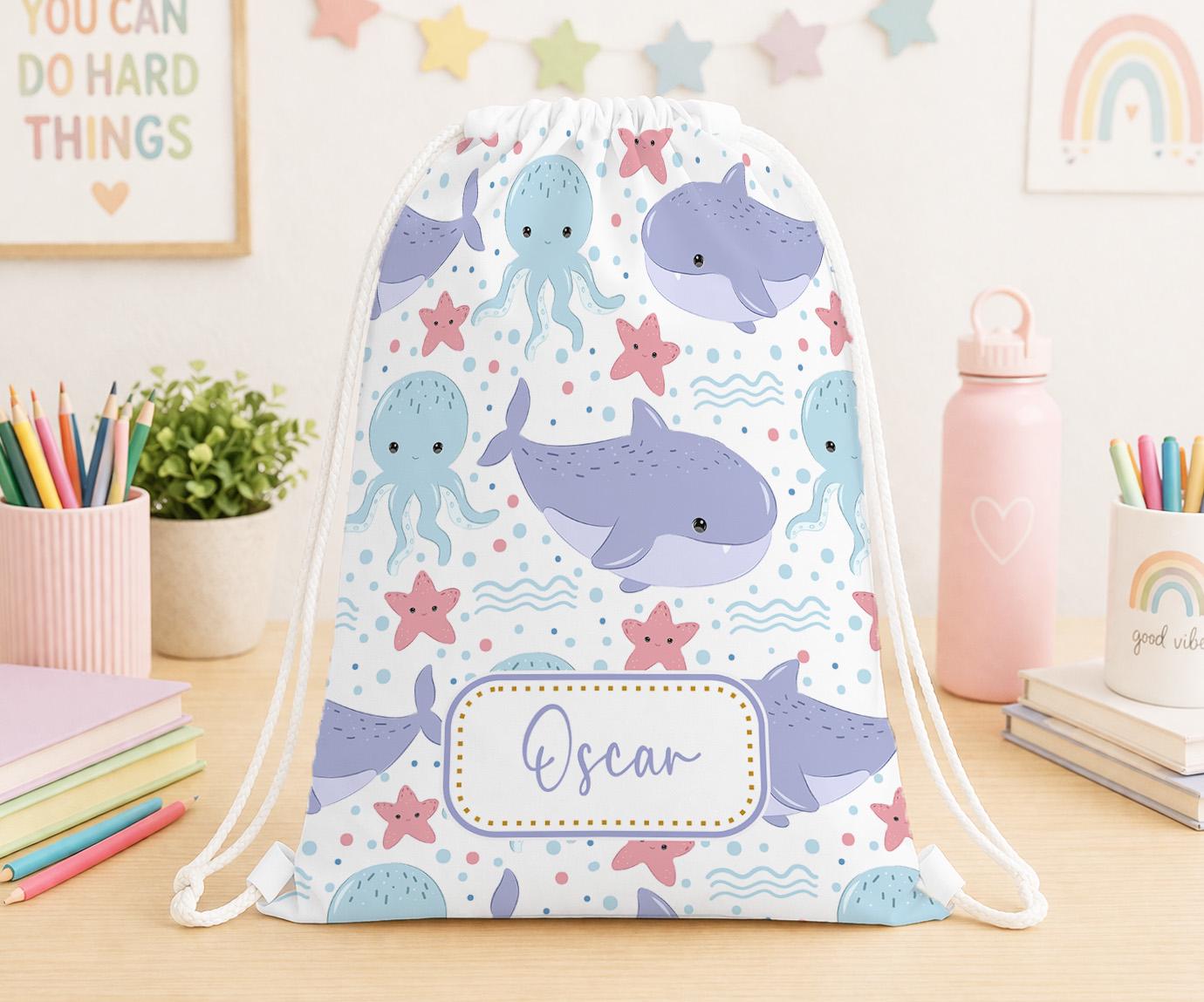 Personalised ocean creatures print drawstring PE bag with a child's name printed on the front, dolphins and fish design