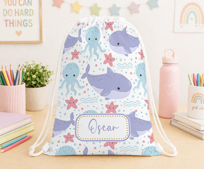 Personalised ocean creatures print drawstring PE bag with a child's name printed on the front, dolphins and fish design