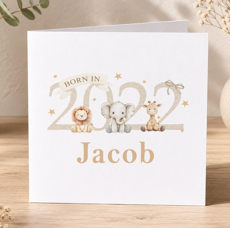 Beige newborn baby card illustrated with a lion, elephant and giraffe, printed with 'Born in 2023 Jacob' as a personalisation example.