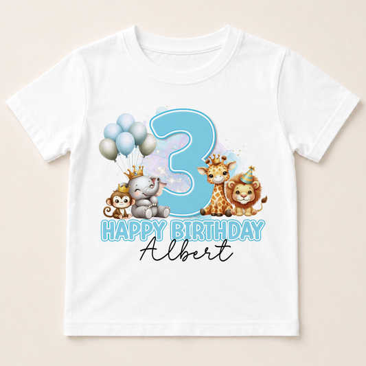 A white t-shirt with a birthday theme featuring a large number 3, surrounded by cartoon animal characters such as a giraffe, lion, and monkey.