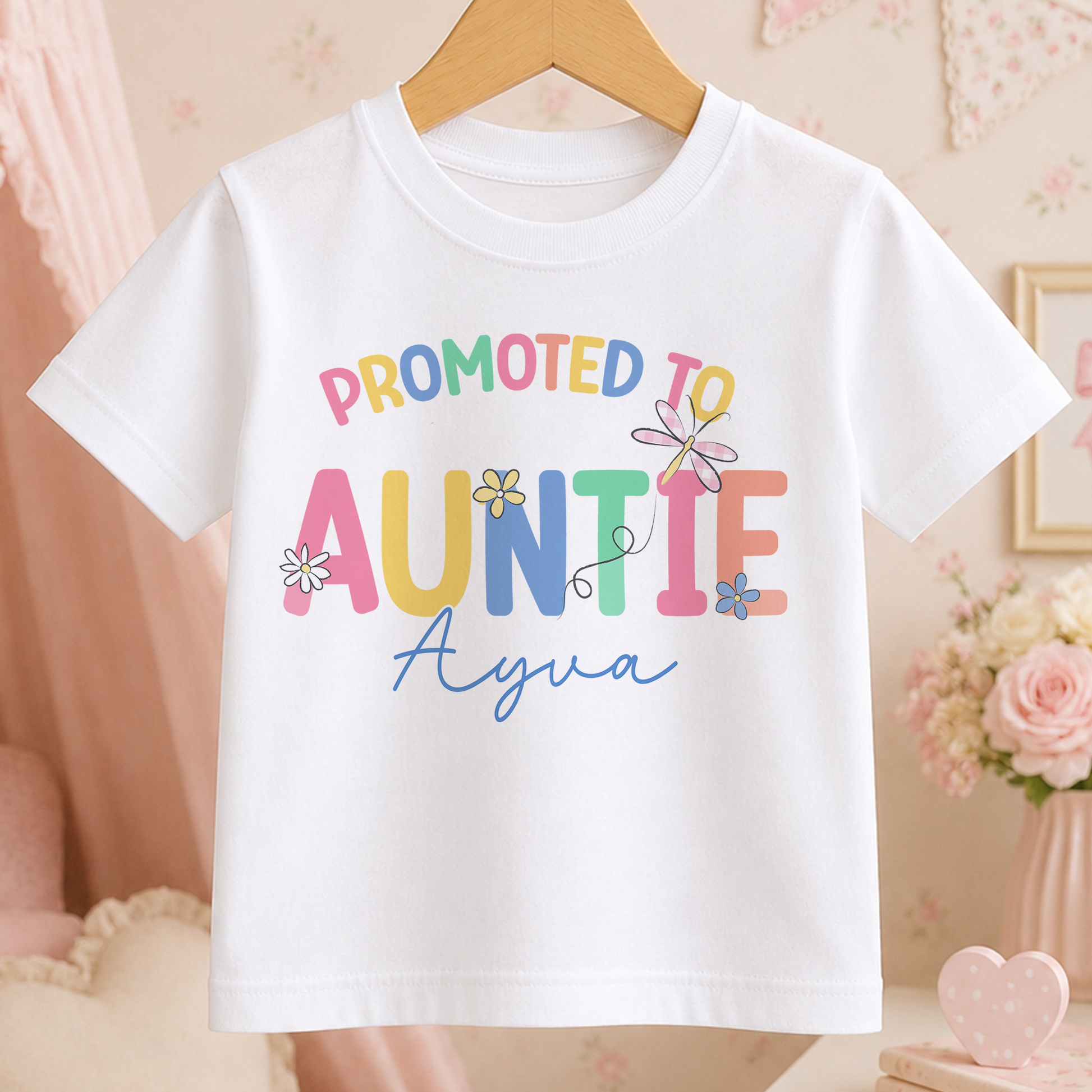 A white t-shirt with the text "PROMOTED TO AUNTIE Ayya" printed on it.