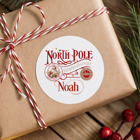 A brown gift box wrapped with red and white twine, featuring a circular label with text and a Santa Claus image.