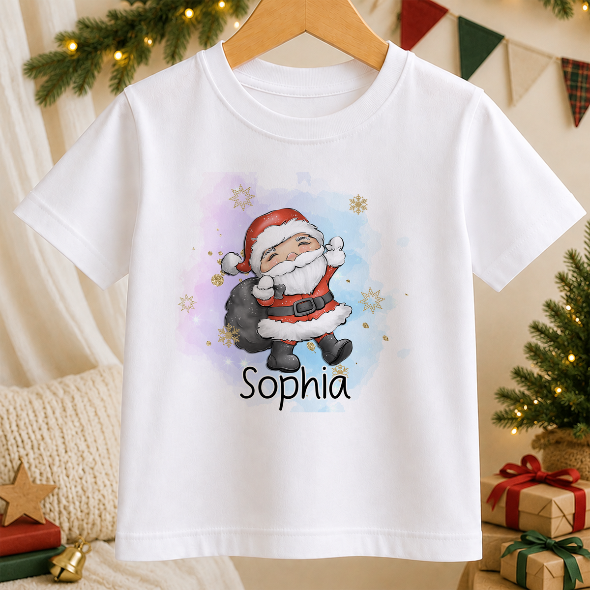 A white t-shirt with a colorful illustration of a smiling Santa Claus character and the name "Sophia" printed on it, hanging on a wooden hanger.