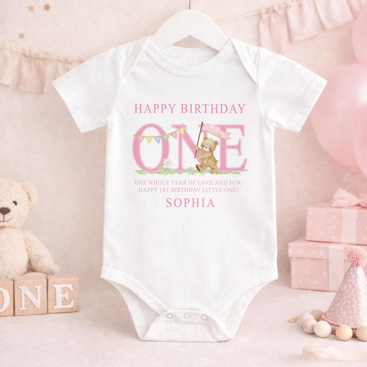 Personalised pink striped first birthday outfit laid flat to show the full design.
