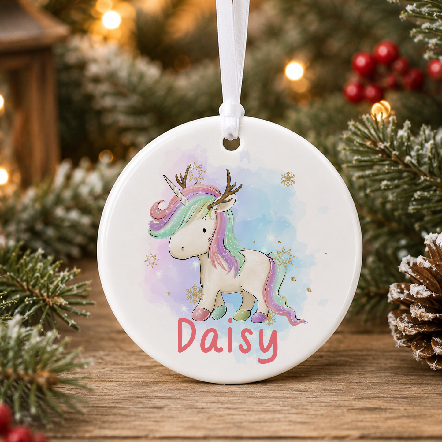 A white ceramic ornament featuring a unicorn with a name tag, surrounded by Christmas decorations and pine branches.