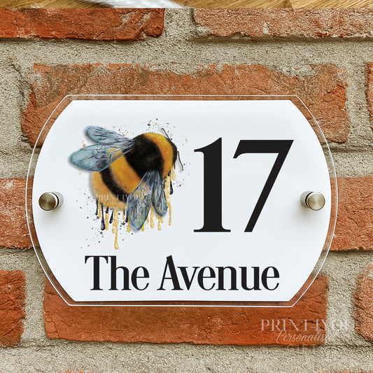 Fluffy bumble bee house number plaque mounted on a brick wall