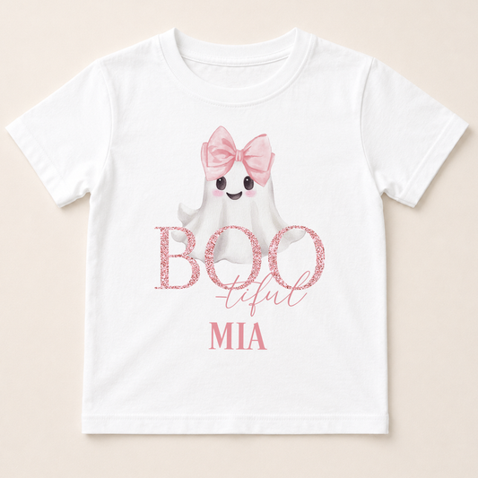 A white t-shirt with a graphic design featuring a ghost character wearing a pink bow and the text "BOO tful MIA" printed on it.