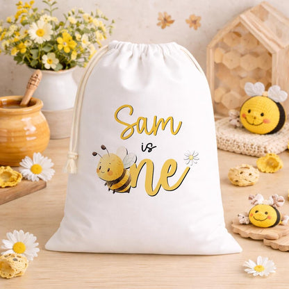 White A3 drawstring party bag printed with a bee-themed design and personalised child's name.