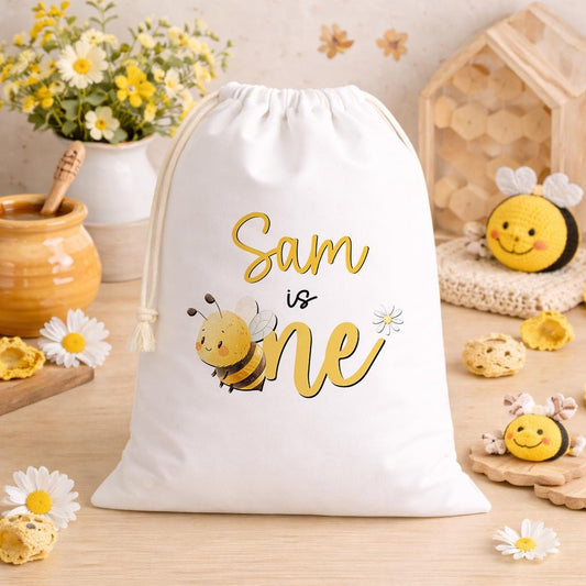 White A3 drawstring party bag printed with a bee-themed design and personalised child's name.