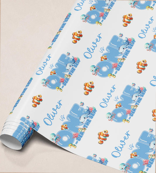 Roll of personalised ocean wrapping paper with a repeating custom name and sea creature pattern