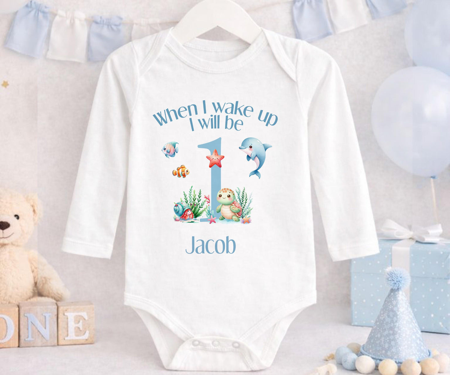 Baby outfit with swimming sea creatures printed alongside the child's personalised name.