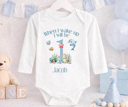 Baby outfit with swimming sea creatures printed alongside the child's personalised name.