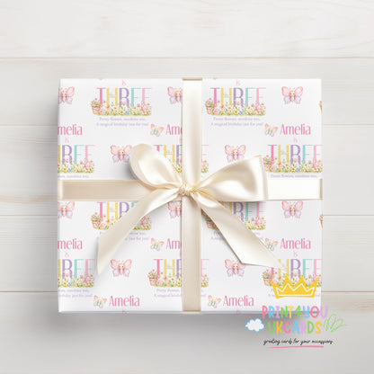 Gift box wrapped in personalised butterfly wrapping paper printed with the name Amelia, finished with white ribbon.