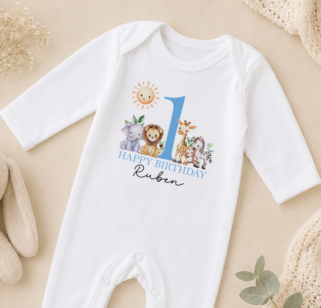A white onesie with a blue number 1 and a design of various animals, including a lion, giraffe, and elephant, along with the text "Happy Birthday Ruben".