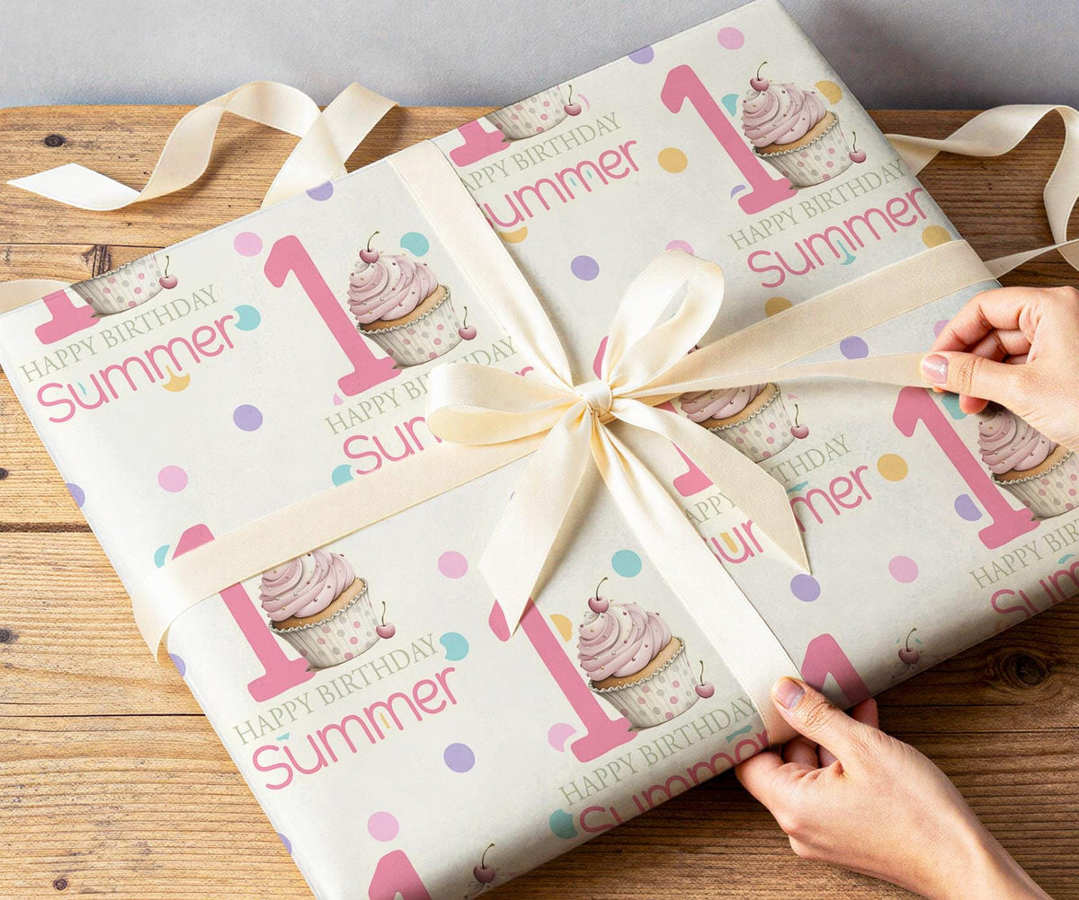 Personalised pink cupcake wrapping paper rolled and shown against a plain background