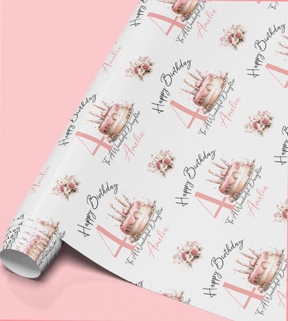 A roll of wrapping paper with a repeating pattern of pink birthday cakes and candles