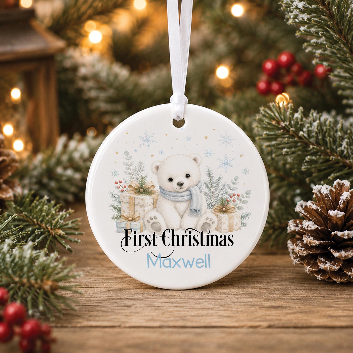 Personalised baby Christmas bauble, white ceramic ornament with a polar bear and festive greenery, printed with baby's name and First Christmas