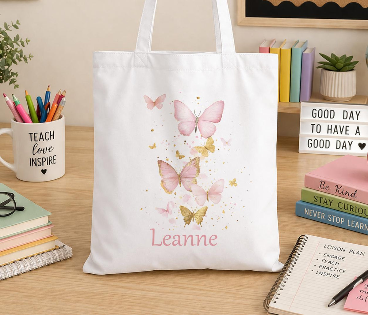 Cream cotton canvas tote bag printed with a soft, delicate butterfly design and personalised with a custom name, shown with shoulder straps