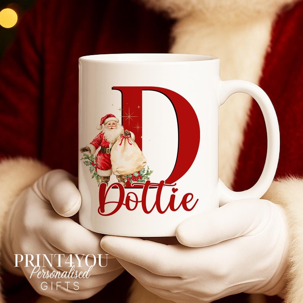 Close-up of a white ceramic mug with red handle personalised with a large letter D featuring a Santa illustration and the name Dottie.