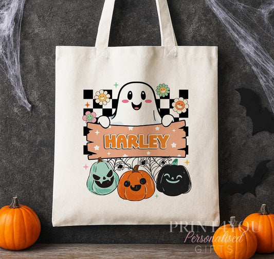 Cotton tote bag printed with a retro ghost, checkerboard background and colourful pumpkins, personalised with a custom name banner.
