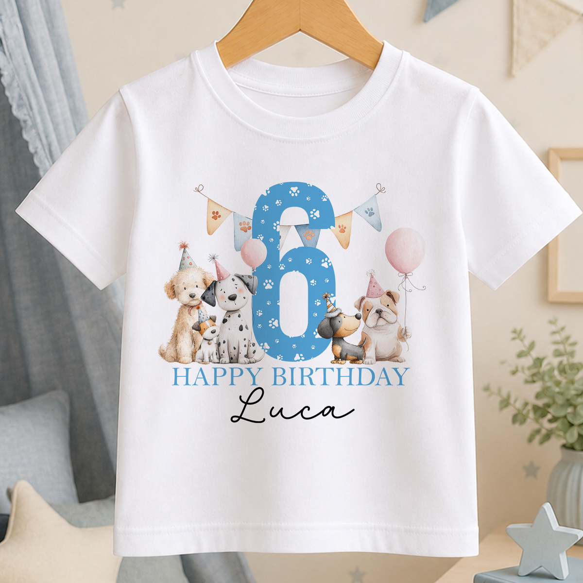 A white t-shirt with a birthday theme, featuring illustrations of dogs and balloons, along with the text "Happy Birthday Luca".
