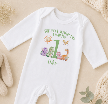A white onesie with a personalized message and illustrations of animals, specifically dinosaurs, printed on it.