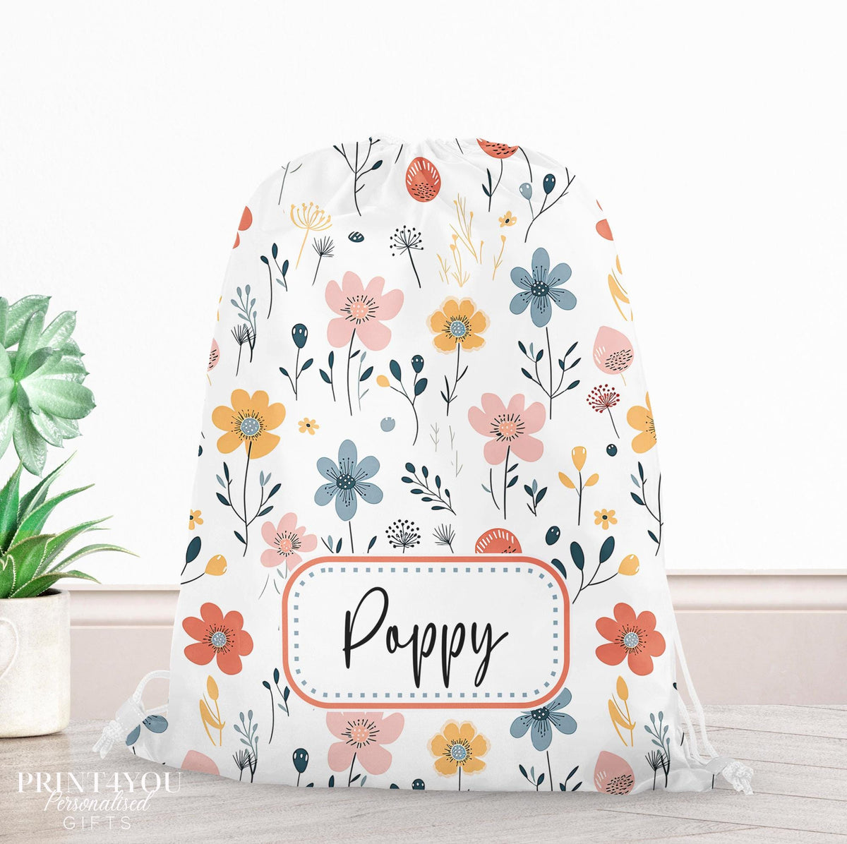 Personalised floral print drawstring PE bag with a child's name printed on the front in a handwritten font