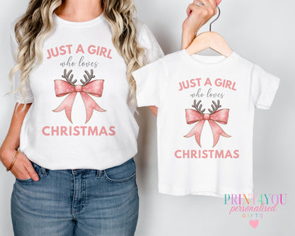Mother and daughter wearing matching "Just a Girl Who Loves Christmas" personalised t-shirts with a festive bow and antlers design