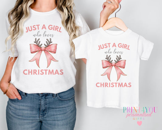 Mother and daughter wearing matching "Just a Girl Who Loves Christmas" t-shirts with a festive bow and antlers design