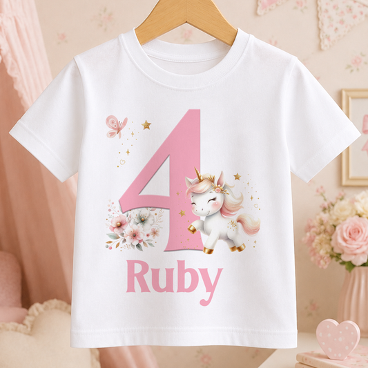 A white t-shirt with a pink unicorn and the number 4 printed on it, along with the name "Ruby" below the number.