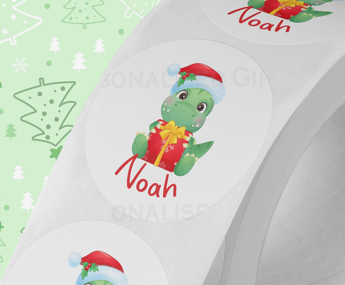 Personalised dinosaur Christmas sticker on a strip – glossy white 5cm round gift label printed with a custom name