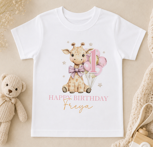 A white t-shirt with a giraffe and balloons, along with the text "Happy Birthday Freya" printed on it.