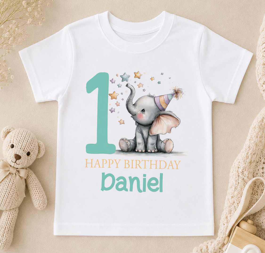 A white t-shirt with a graphic design featuring a baby elephant wearing a party hat and surrounded by stars, along with the text "Happy Birthday Daniel".