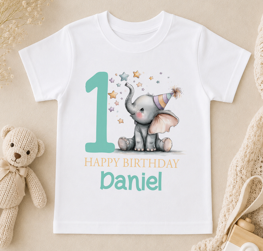 A white t-shirt with a graphic design featuring a baby elephant wearing a party hat and surrounded by stars, along with the text "Happy Birthday Daniel".