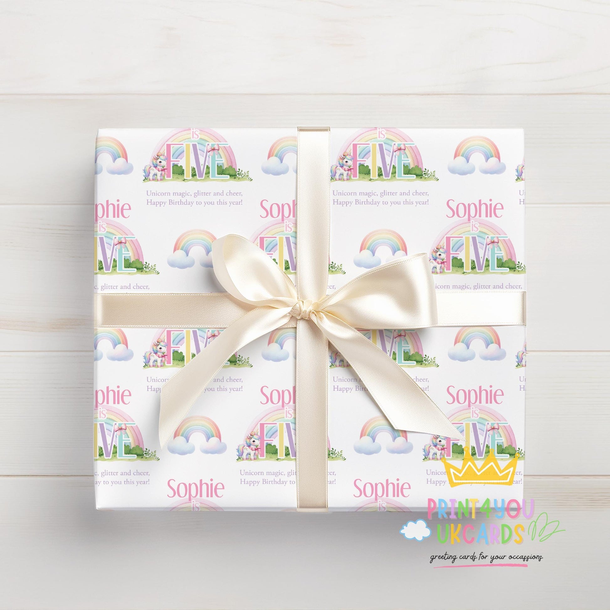 Personalised rainbow unicorn birthday wrapping paper wrapped around a gift