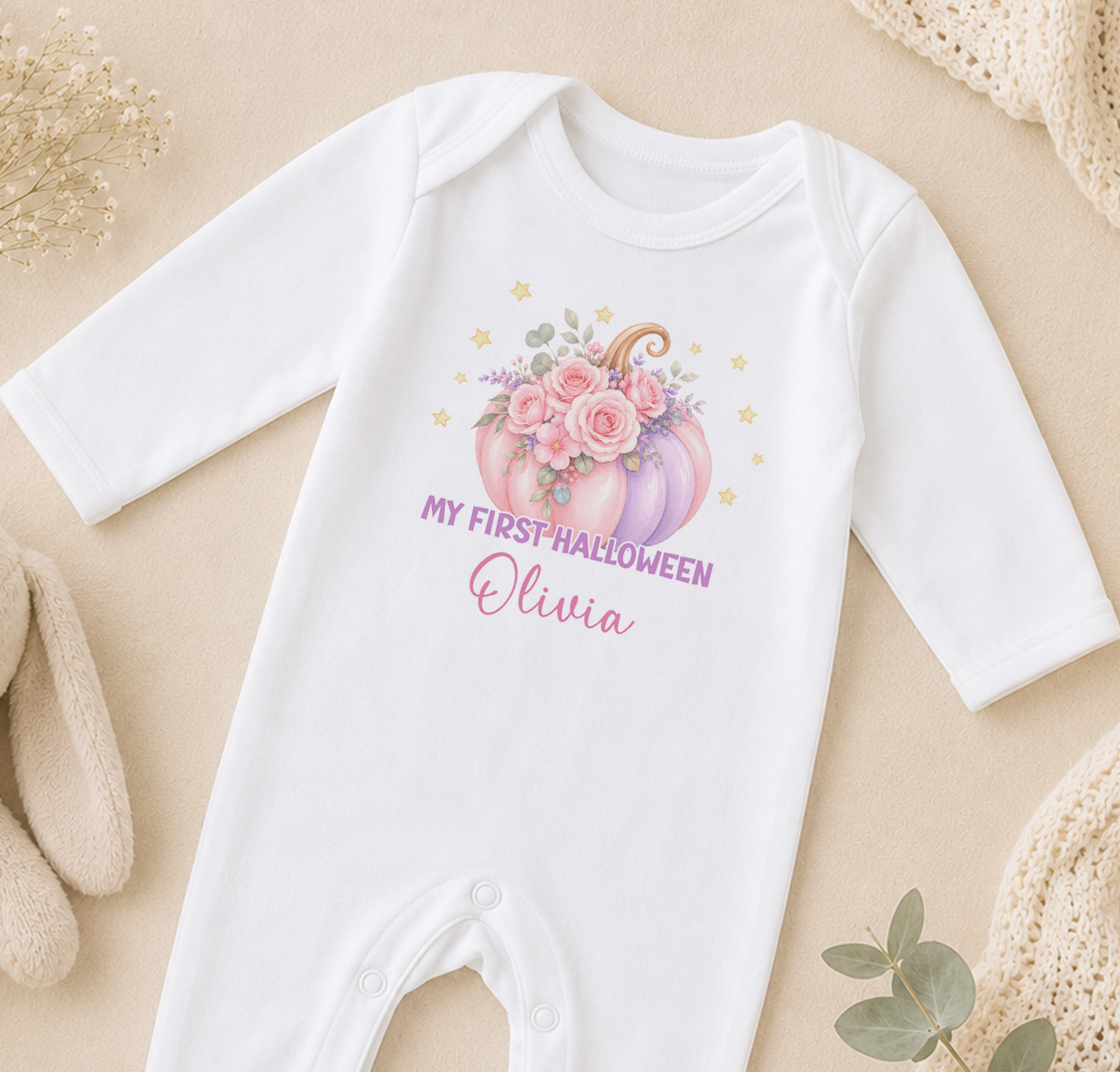 A white onesie with a pumpkin and flowers design, along with the text "My first Halloween Olivia" printed on it.