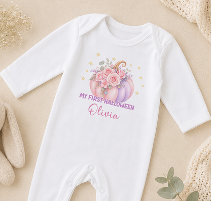 A white onesie with a pumpkin and flowers design, along with the text "My first Halloween Olivia" printed on it.