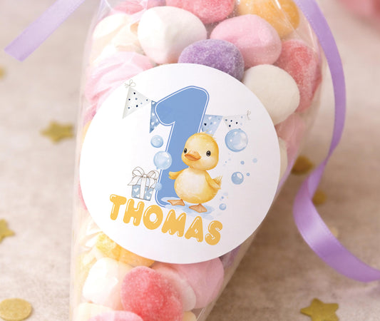 Sheet of glossy personalised 1st birthday duck stickers featuring cartoon ducks and party bunting, ready for a baby boy's birthday party bags