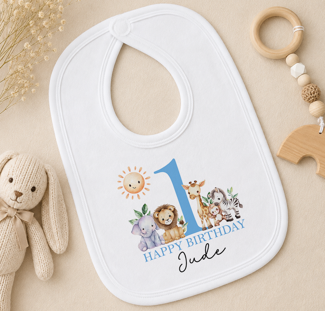 Personalised white bib printed with a blue number 1, jungle animals and 'Happy Birthday Jude'.
