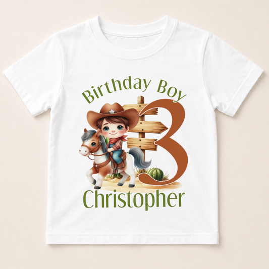 A white t-shirt with a cartoon image of a boy riding a horse and holding a sign that says "Birthday Boy Christopher".