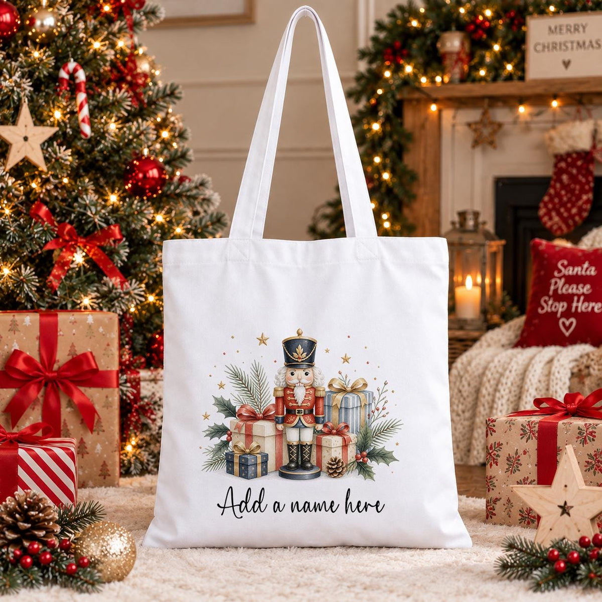 White cotton tote bag printed with a watercolour nutcracker toy soldier among wrapped presents and pine, above a name in script.
