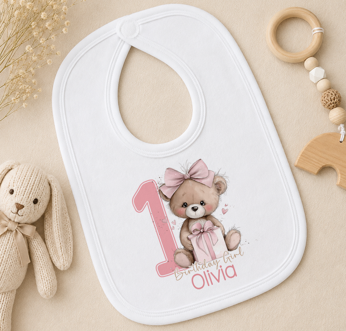 Personalised pink teddy bear first birthday bib printed with Birthday Girl and custom name.
