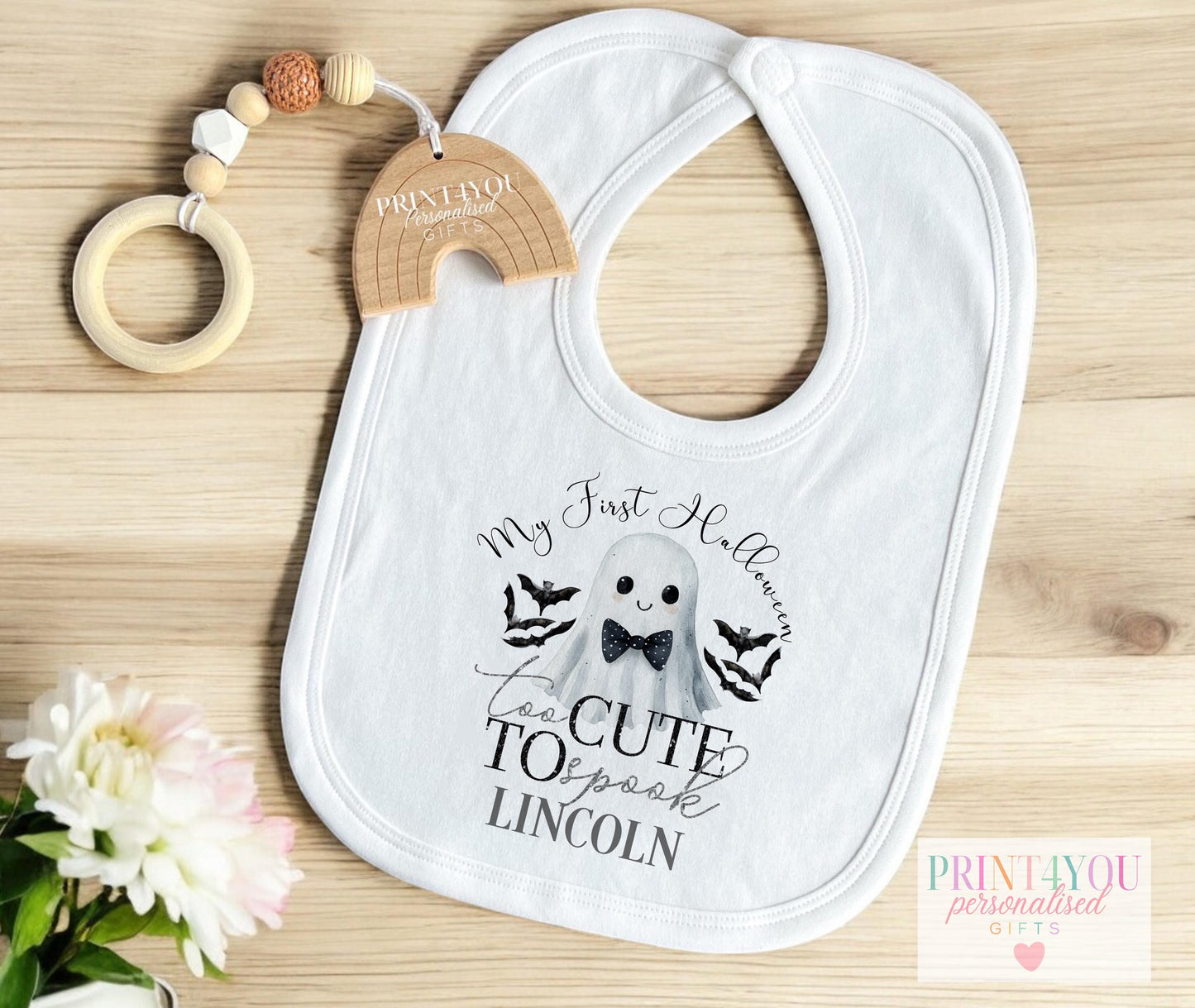 Personalised Halloween baby vest with bow-tie ghost design, laid flat to show full print.