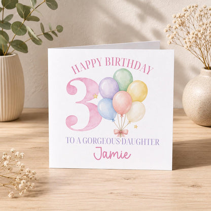Square personalised birthday card standing upright next to its white envelope on a plain background.
