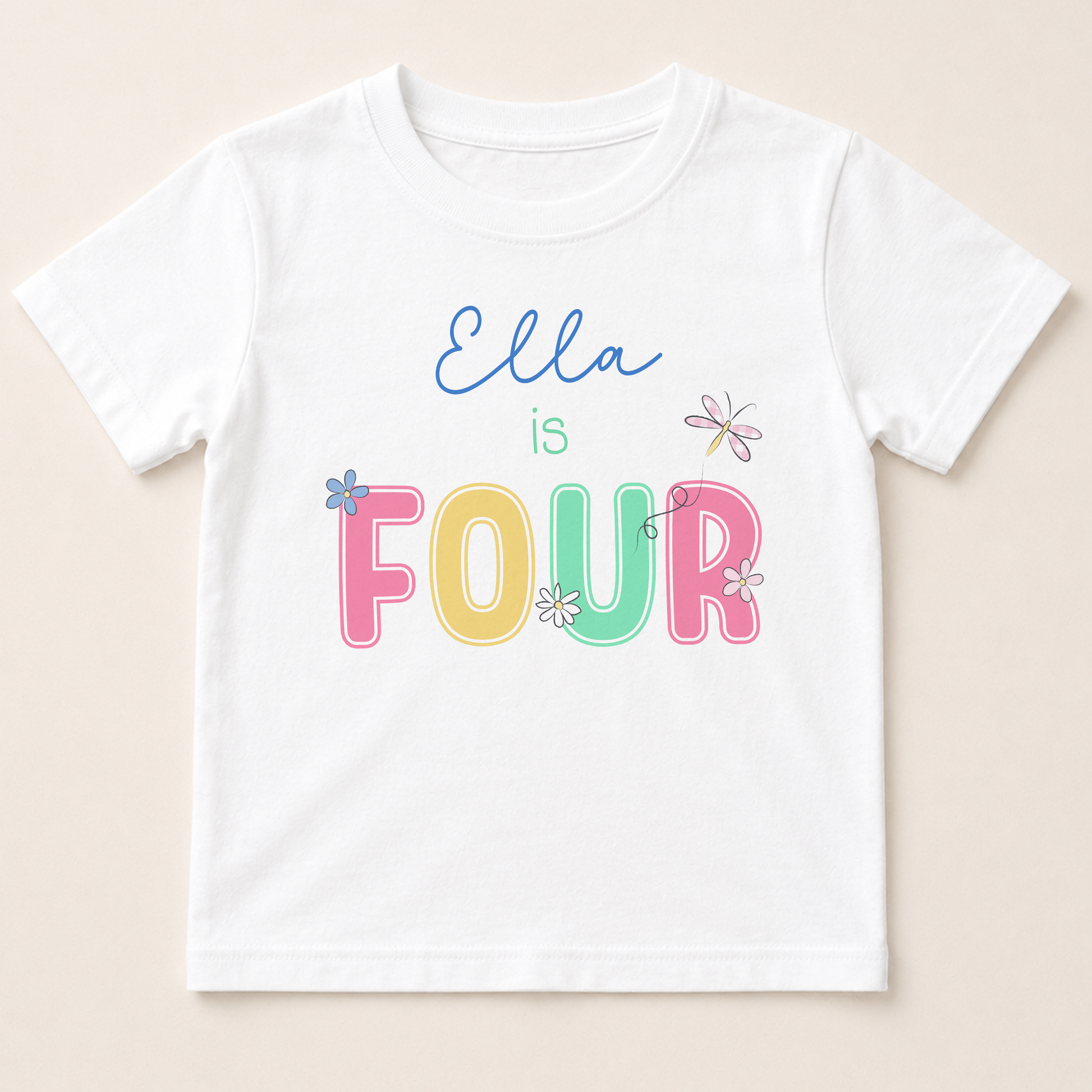 A white t-shirt with the text "Ella is FOUR" printed on it in a colorful, playful font.