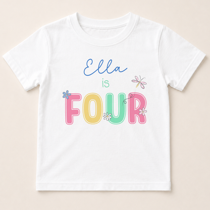 A white t-shirt with the text "Ella is FOUR" printed on it in a colorful, playful font.
