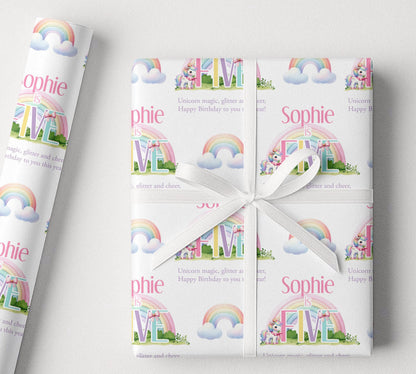 Sheet of personalised rainbow unicorn birthday wrapping paper laid flat